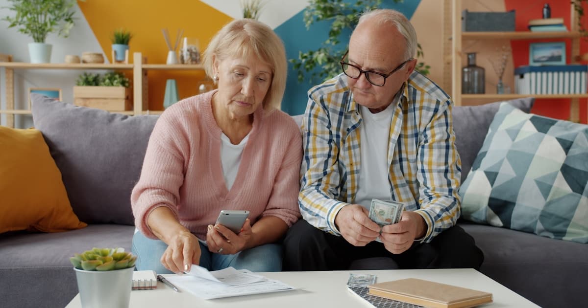 Retired couple reviewing financial documents and planning CPP timing